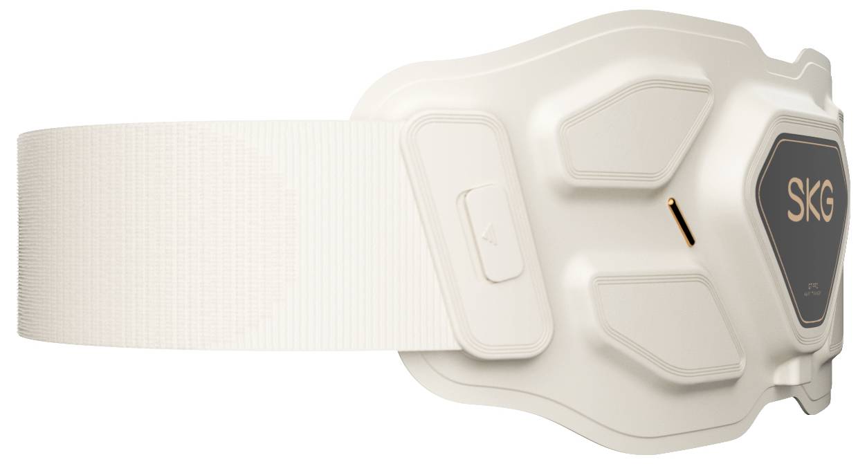 Bílé wearable zařízení SKG se širokým páskem, zobrazené v bočním pohledu na jednoduchém pozadí.