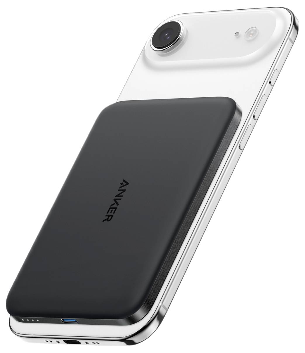 Černá magnetická powerbanka Anker připojená na zadní straně bílého iPhonu, zobrazující bezdrátové nabíjení na jednobarevném pozadí.