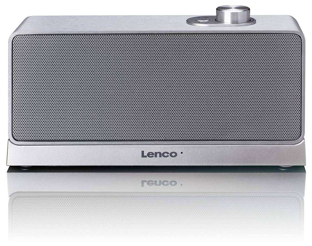 Stříbrný přenosný reproduktor nebo rádio Lenco se velkým předním mřížkou a jedním ovládacím kolečkem na horní straně na bílém pozadí.