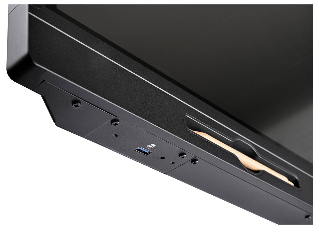 Detailní snímek okraje černého zařízení s modrým portem USB a zapuštěným madlem, zobrazeným na bílém pozadí.