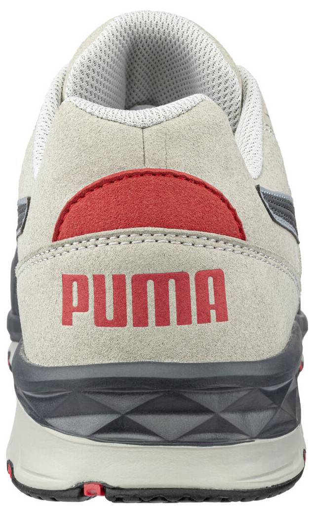 Zadní pohled na béžovou tenisku Puma s červeným logem a černou podešví na bílém pozadí.