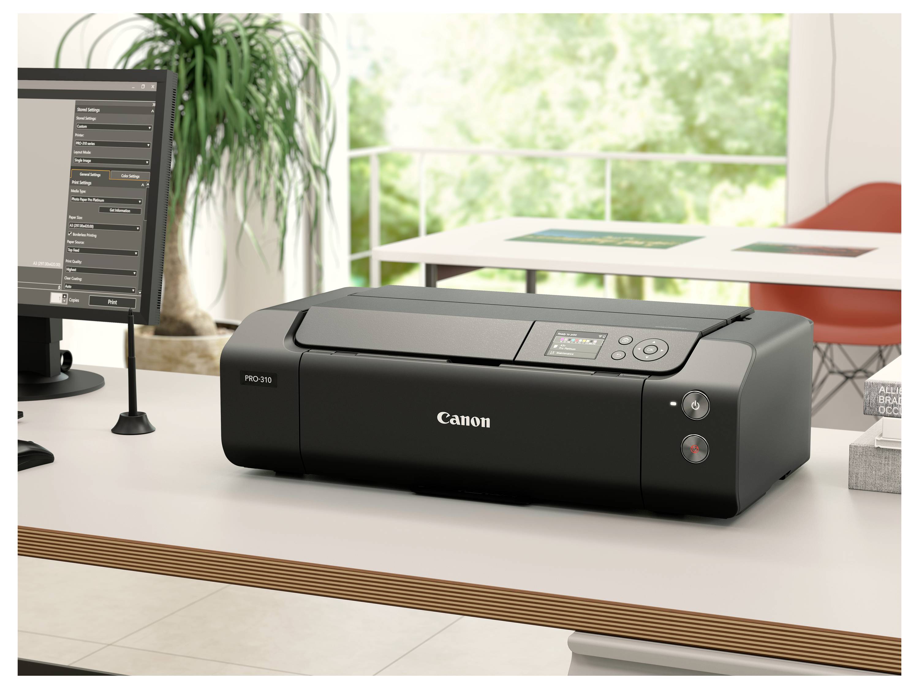 Kancelářská tiskárna Canon na stole v jasné kanceláři s počítačovým monitorem vlevo a oknem, stolem a židlí v pozadí.