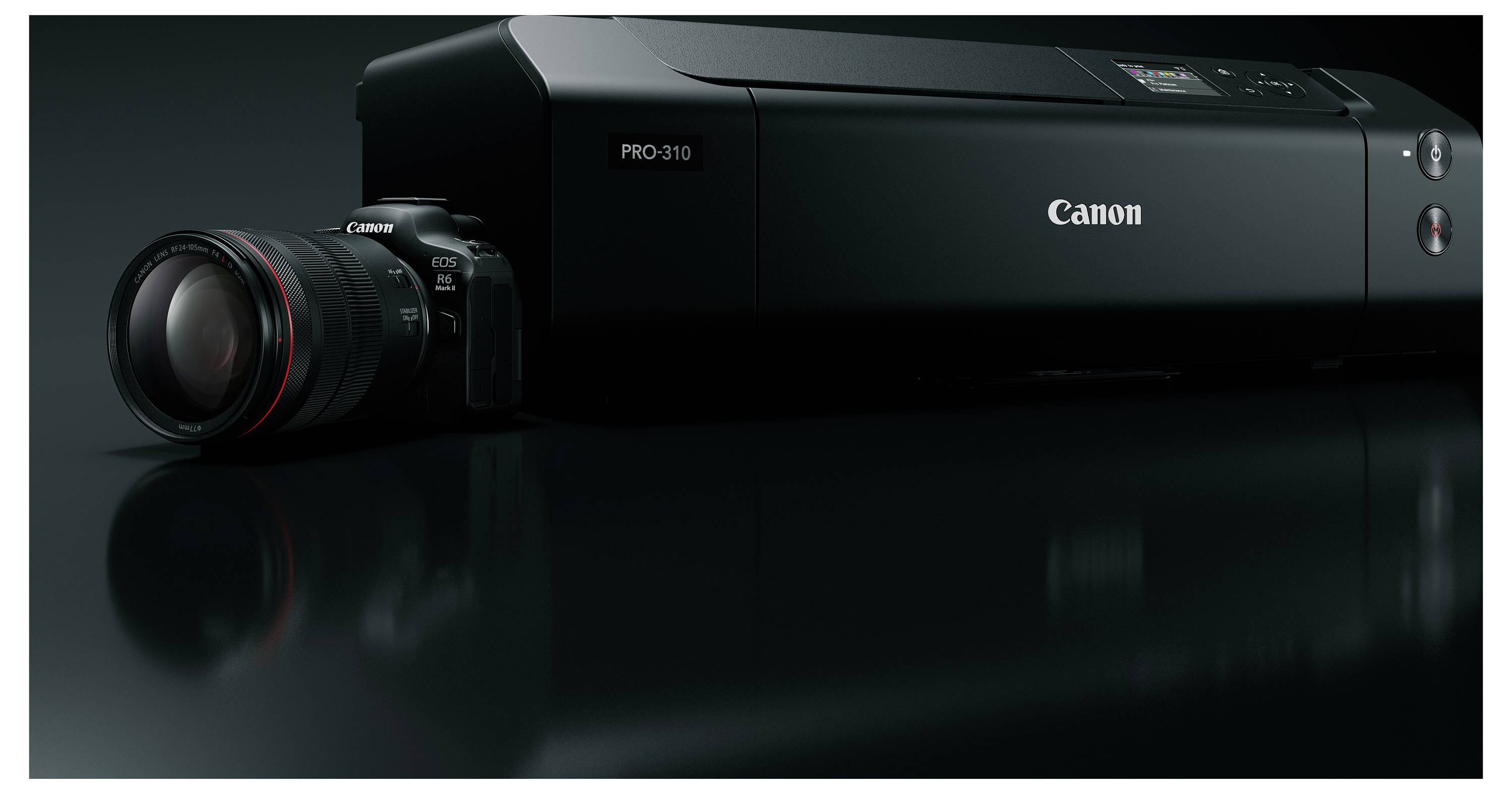 Canon PRO-310 tiskárna vedle objektivu Canon fotoaparátu, zobrazena v temné studijní produktové fotografii s lesklým odrazem.