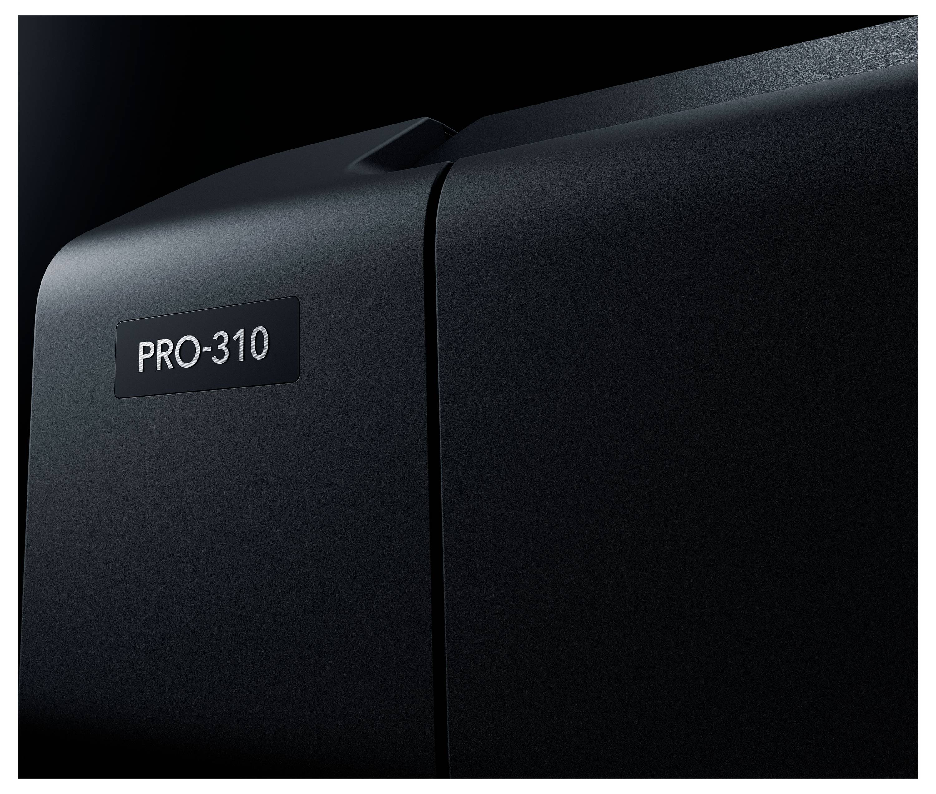 Detailní záběr černého zařízení s popisem "PRO-310", který ukazuje jeho zakřivenou horní část a postranní švem.