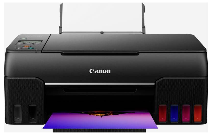 Přední pohled na inkoustový tiskárnu Canon tiskující barevnou stránku, s viditelnými nádrží inkoustu na pravé straně a zásobníkem papíru nahoře.