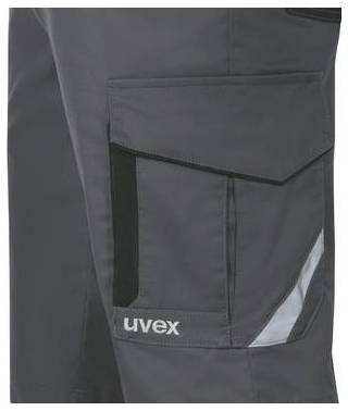 Detailní pohled na tmavě šedé pracovní kalhoty s velkým nákladním kapsou a reflexním pruhem, zobrazující logo 'uvex' na stehně.