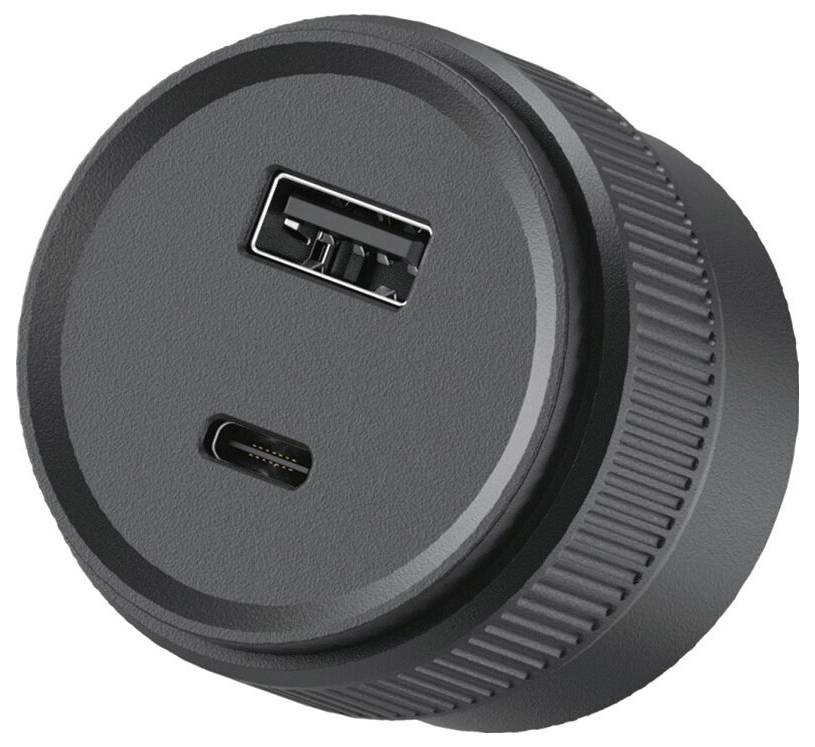 Kulatý černý napájecí adaptér nebo nabíječka s porty USB-A a USB-C na přední straně.