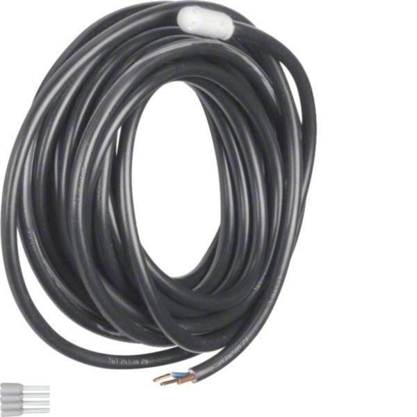 Stočený černý elektrický kabel s odkrytými konci drátů a bílým štítkem na jednoduchém pozadí.
