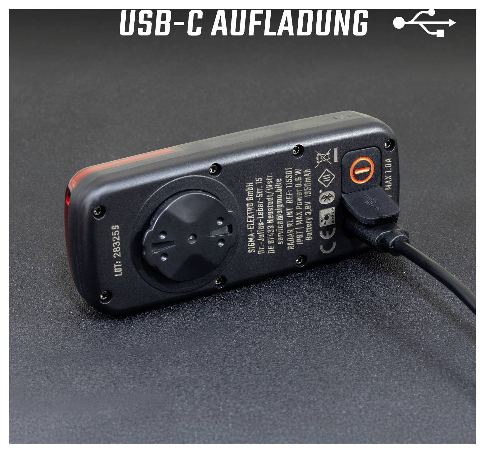 USB-C nabíječka s vestavěným kabelem; oranžově svítící spínač indikuje aktivní proces nabíjení.