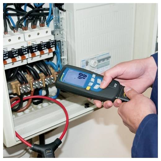 Technik používající přenosný elektrický tester na vedení uvnitř otevřeného rozvaděče.