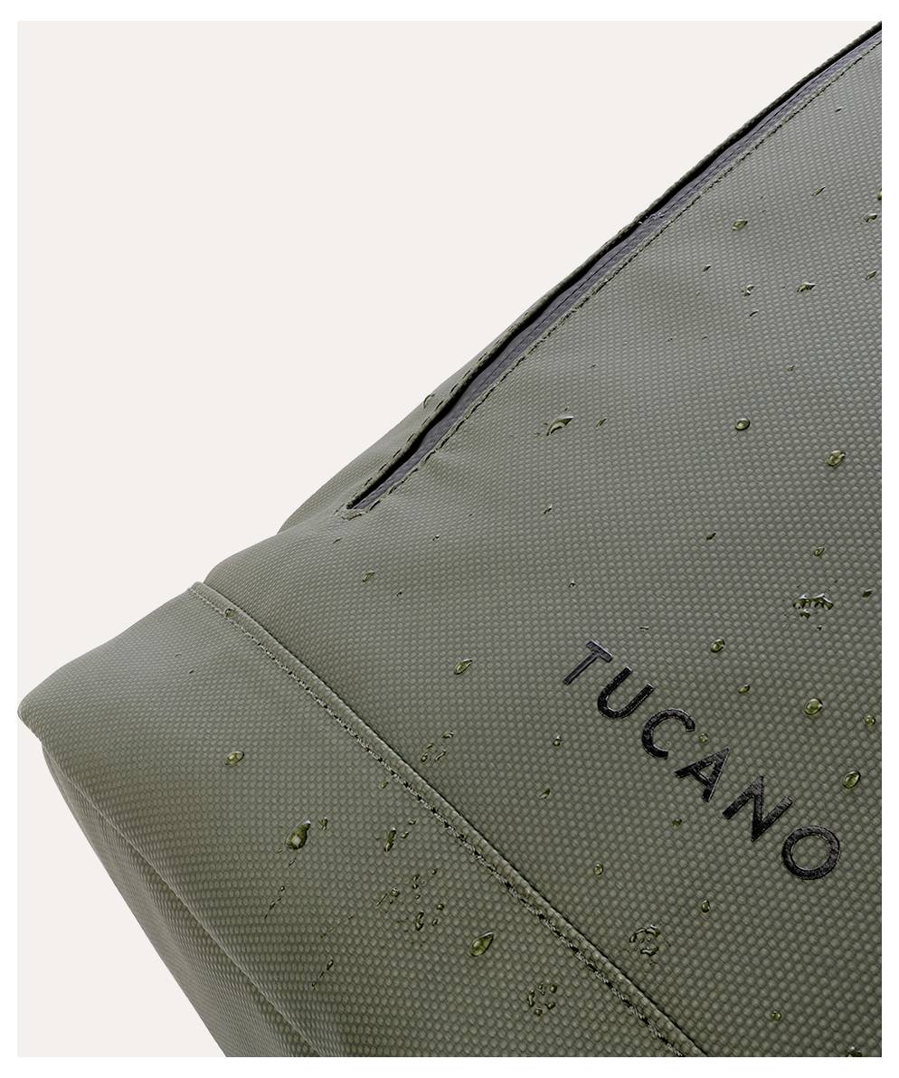 Detailní snímek rohu zelené tašky nebo pouzdra Tucano s kapkami vody na tkanině.