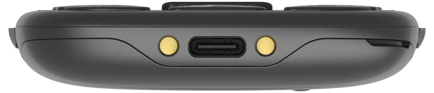 Dolní pohled na tmavě šedé přenosné zařízení zobrazující centrálně umístěný port USB-C obklopený dvěma malými zlatými kruhovými tlačítky nebo indikátory.