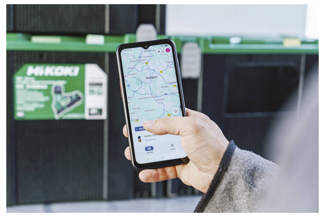 Osoba používá mapovou aplikaci na smartphonu k vyhledání místa poblíž zelených kontejnerů na recyklování Hikoki.