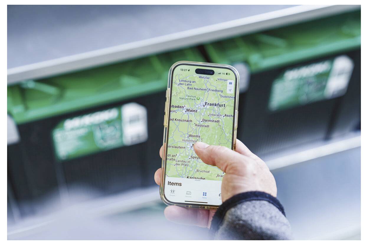 Osoba držící smartphone s otevřenou aplikací mapy zobrazující oblast Frankfurtu a okolní města, jako by kontrolovala směr nebo polohu.