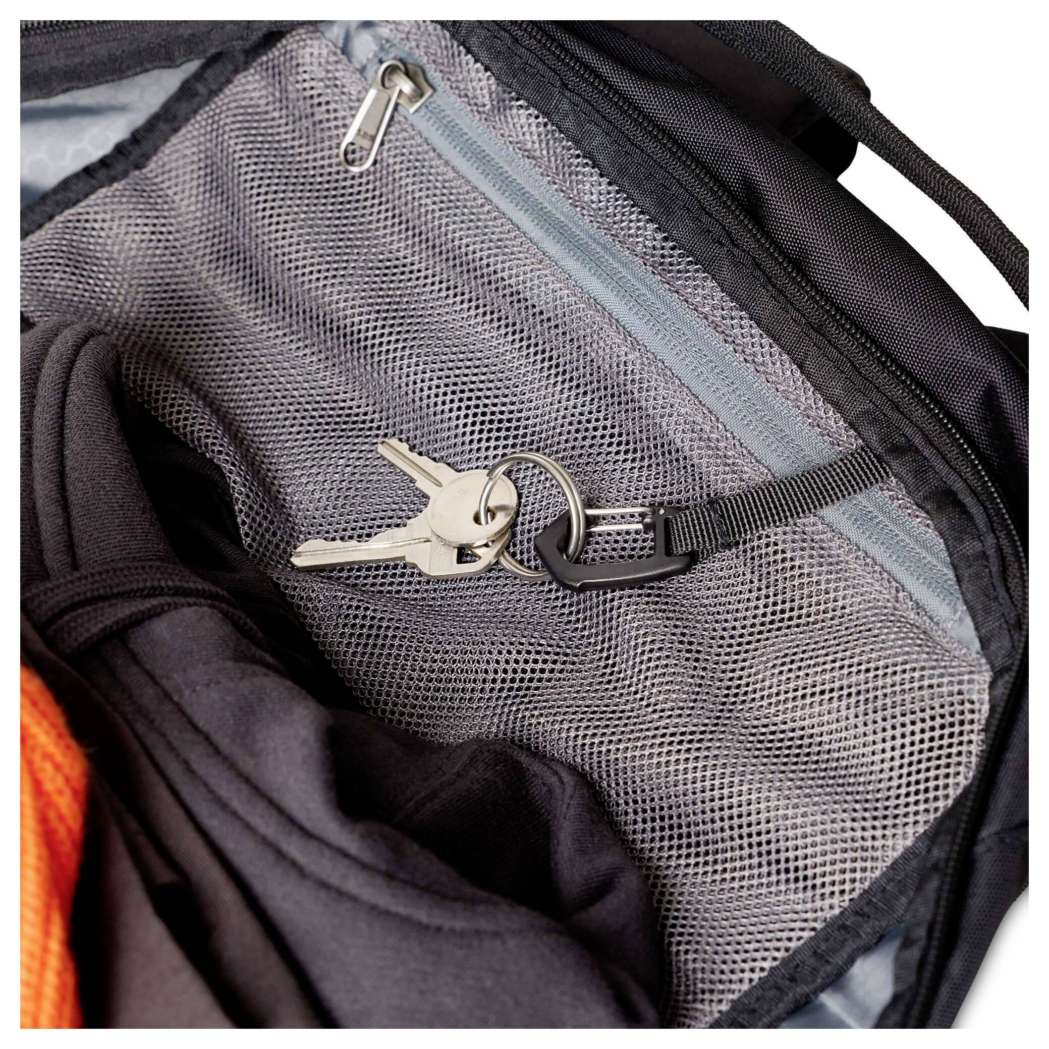 Klíče zapnuté na zip síťované kapsičky černého batohu uvnitř tašky