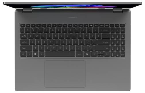 Pohled shora na otevřený šedý notebook s černou klávesnicí a velkým centrálně umístěným touchpadem.