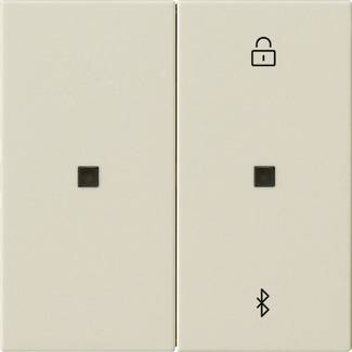 Dva béžové nástěnné vypínače vedle sebe; pravý vypínač má nad sebou ikonu odemčeného zámku a pod sebou symbol Bluetooth.