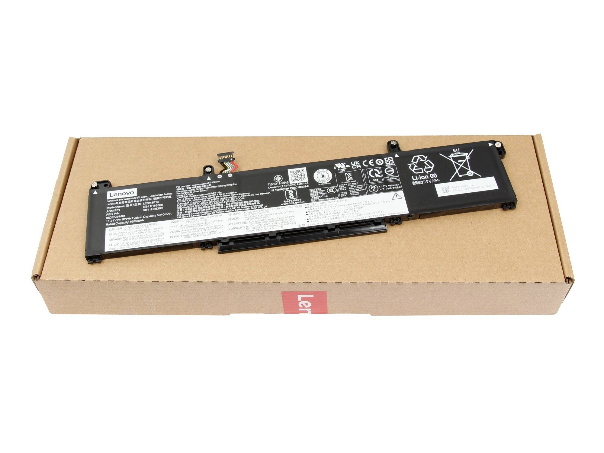 Černý akumulátor notebooku ležící na kartónovém krabici na bílém pozadí.