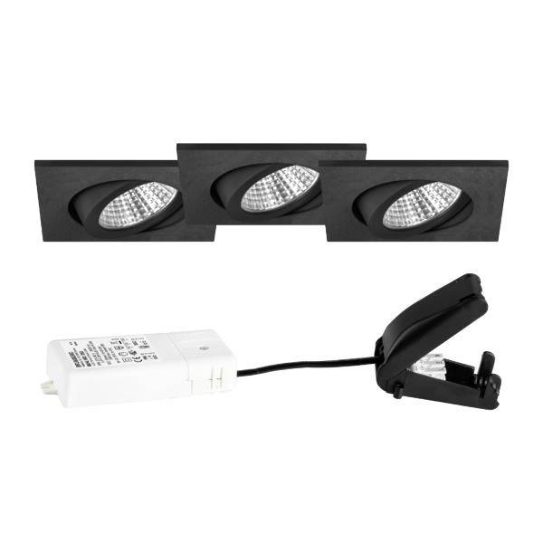 Tři černé zapuštěné LED svítidla s bílým ovladačem a černým upevňovacím khardware se stiskací klipem na bílém pozadí.