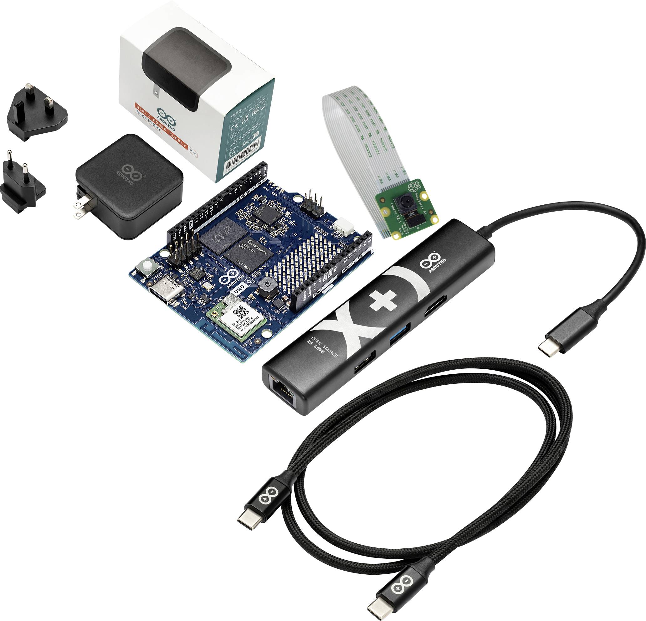 Arduino kit s deskou mikrokontroléru, USB-C kabelem, sadou baterií, páskový kabel a adaptéry napájení, zobrazeny jako součásti v balení.