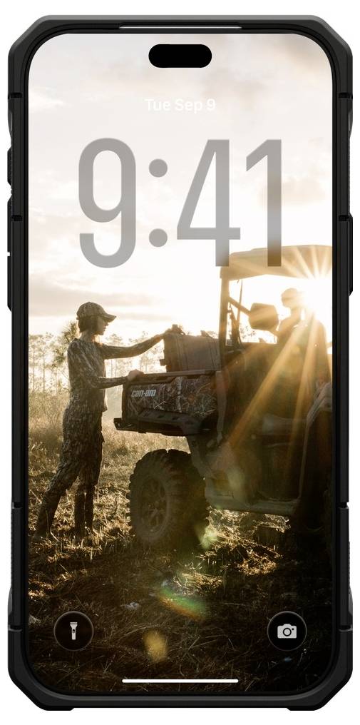 Displej zámku chytrého telefonu zobrazující "Úterý 9. září" a 9:41 přes fotografii při západu slunce se dvěma osobami nakládajícími užitkové vozidlo na poli.