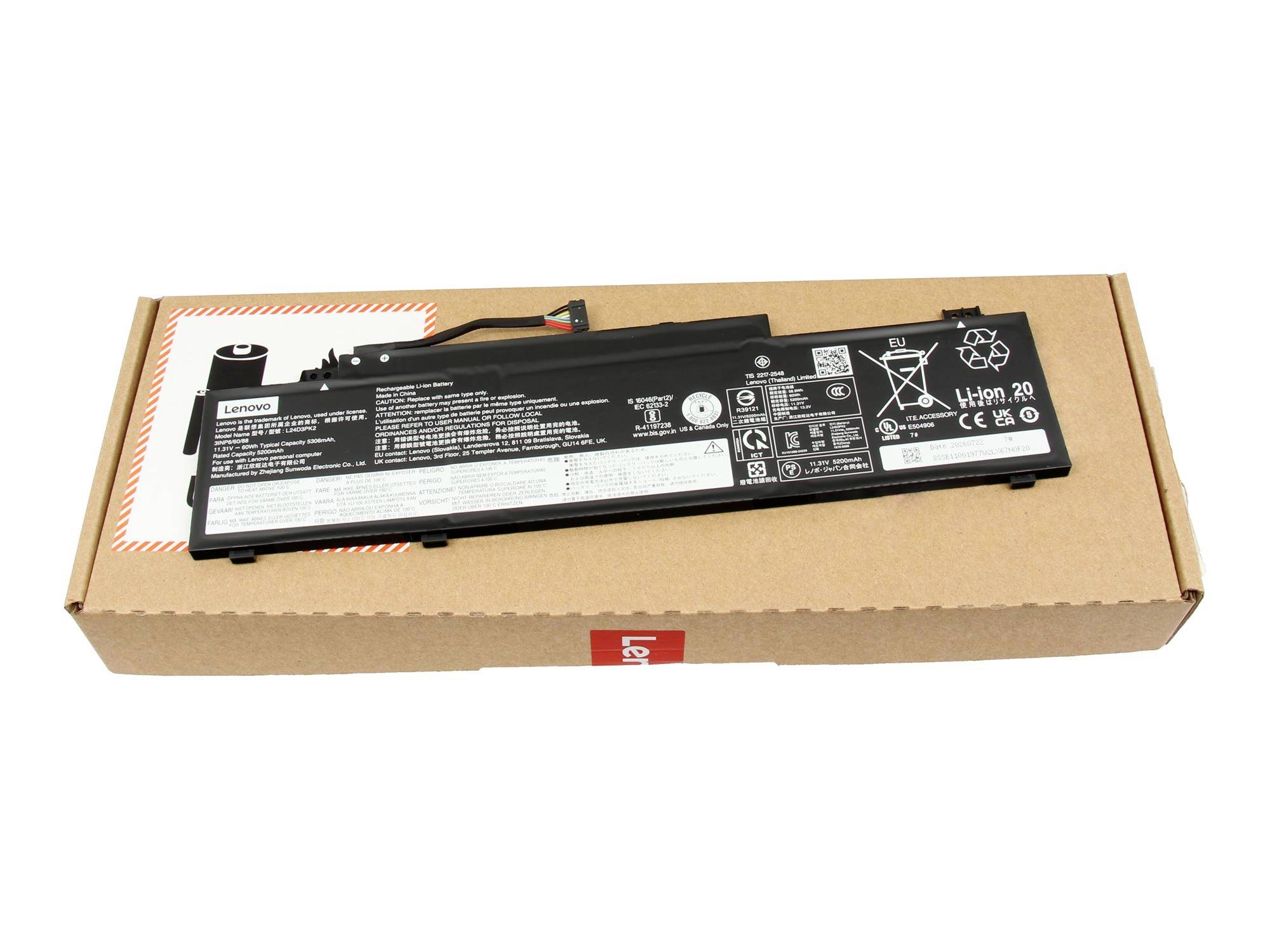 Baterie notebooku Lenovo ležící na kartonové přepravní krabici na bílém pozadí.