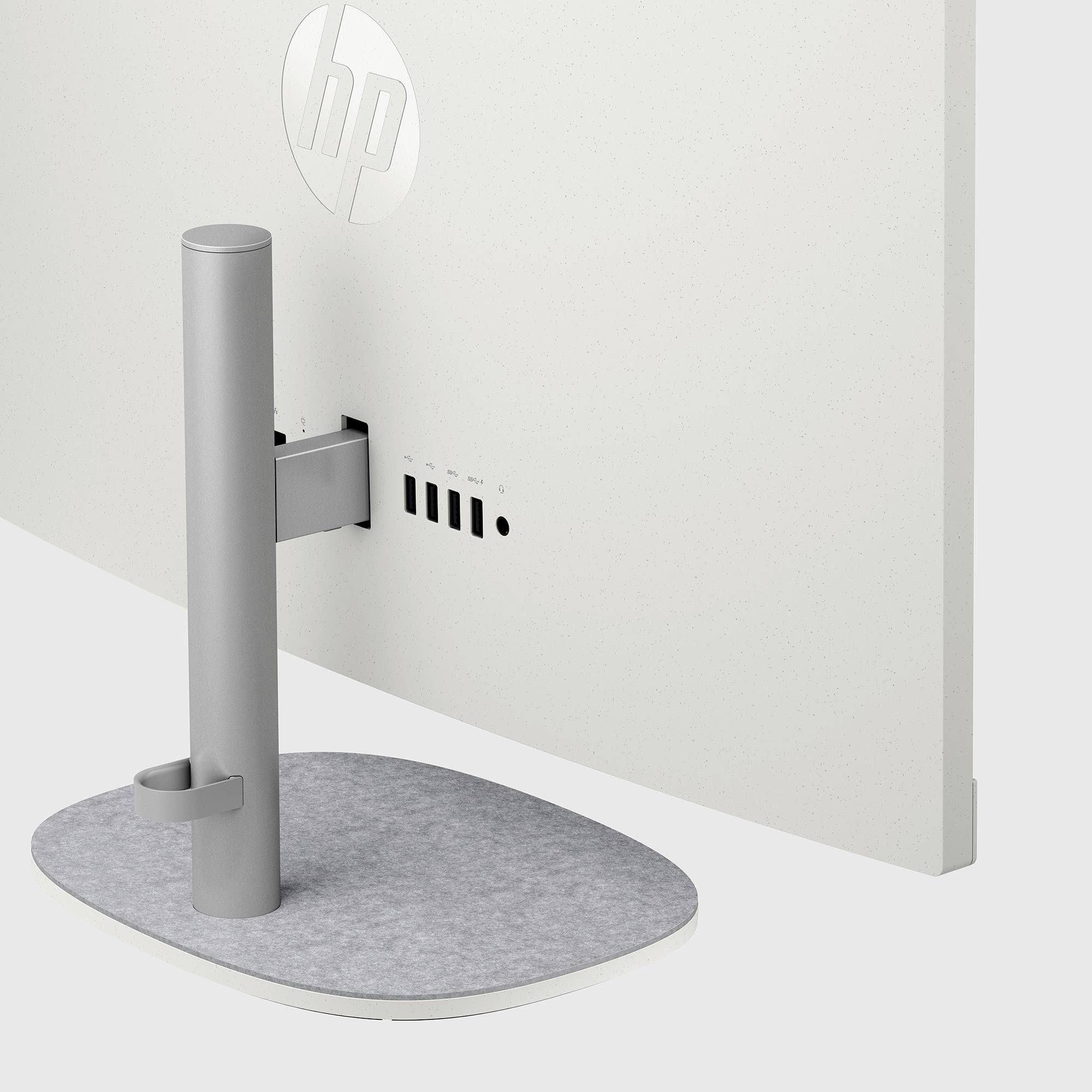 Zadní pohled na monitor HP s šedým válcovitým stojanem a oválnou základnou, zobrazující porty kabelů na zadním panelu.
