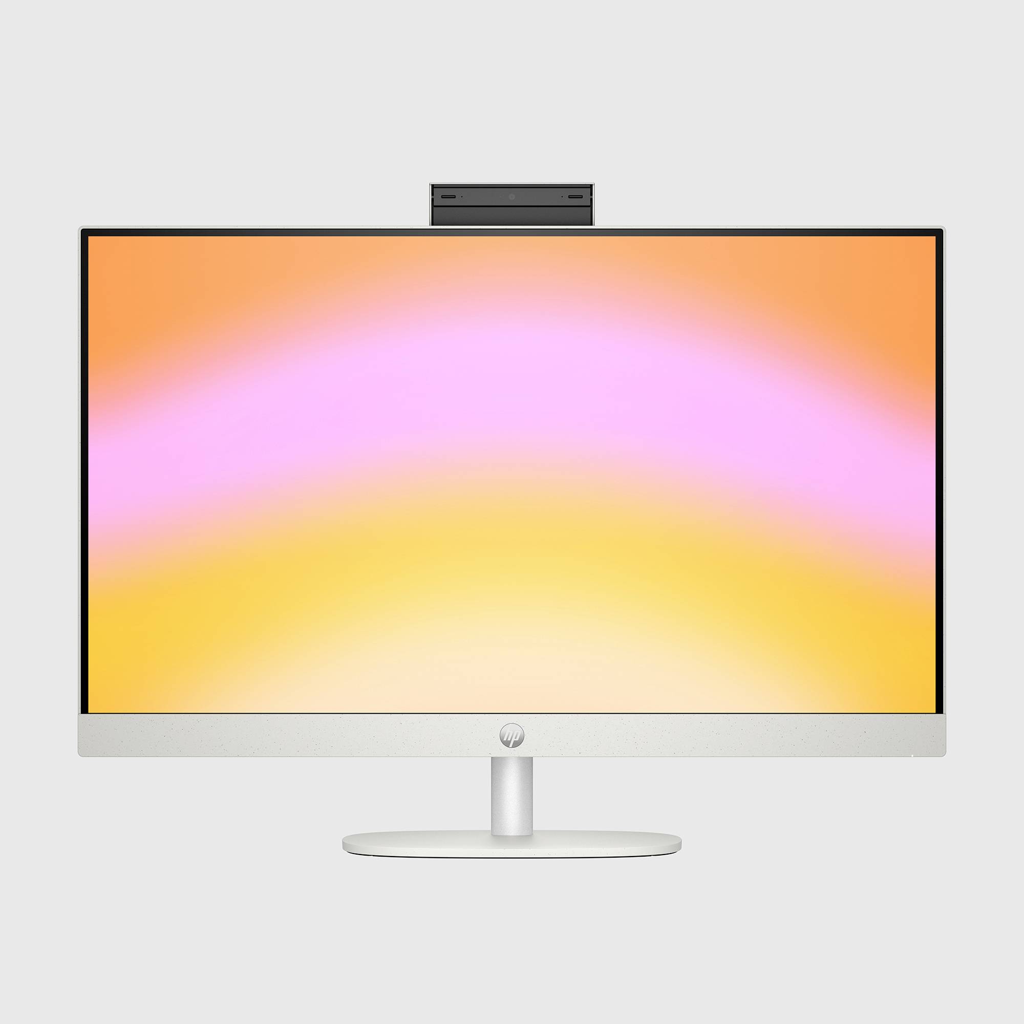Stříbrný stolní monitor s webkamerou na vrcholu zobrazuje obrazovku s pastelovým gradientem v oranžové, růžové a žluté barvě.