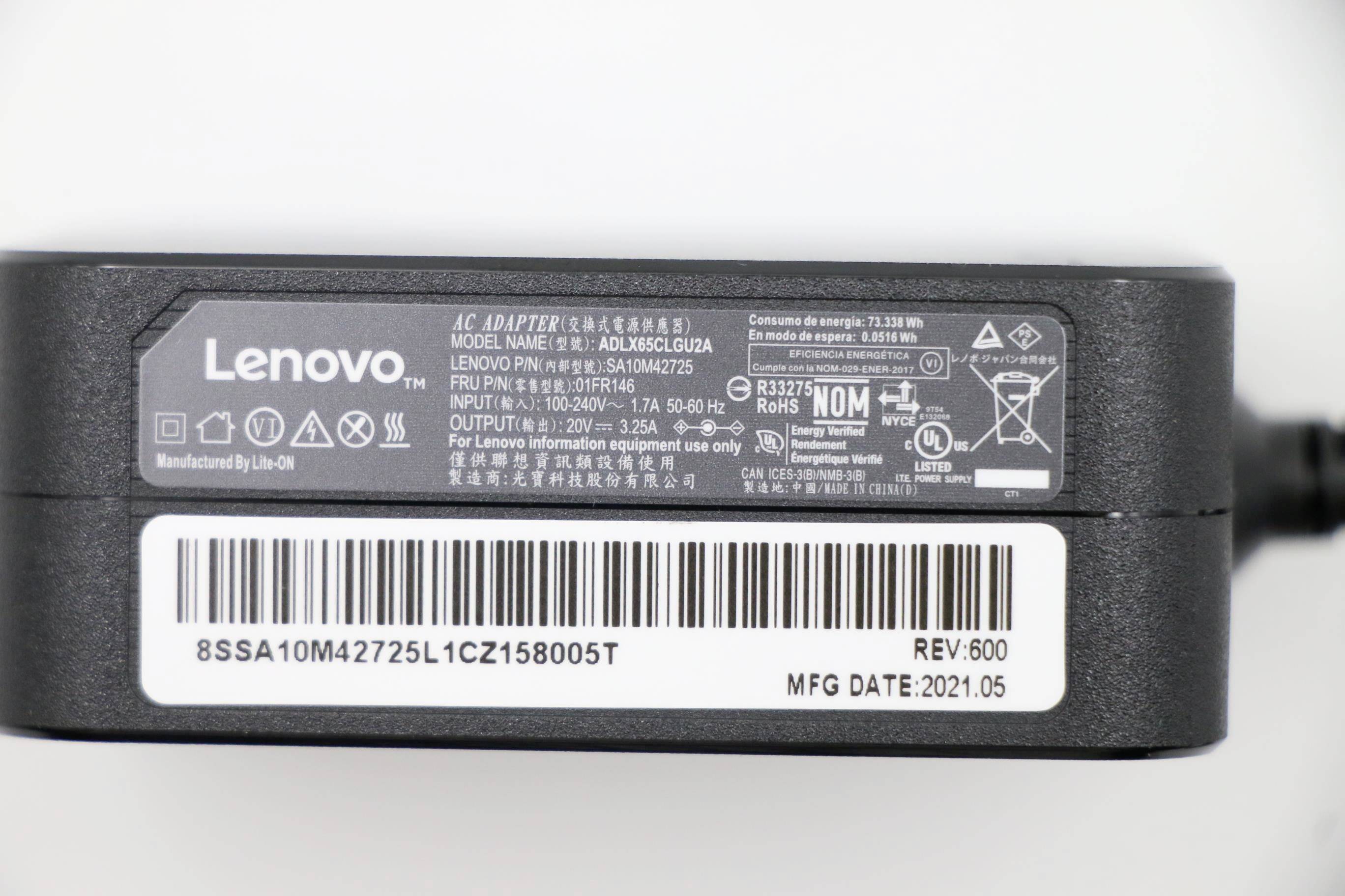 Detailní snímek štítku adaptéru Lenovo AC zobrazující model a certifikační údaje, s čárovým kódem, sériovým číslem, verzí 600 a datem výroby 2021.05.
