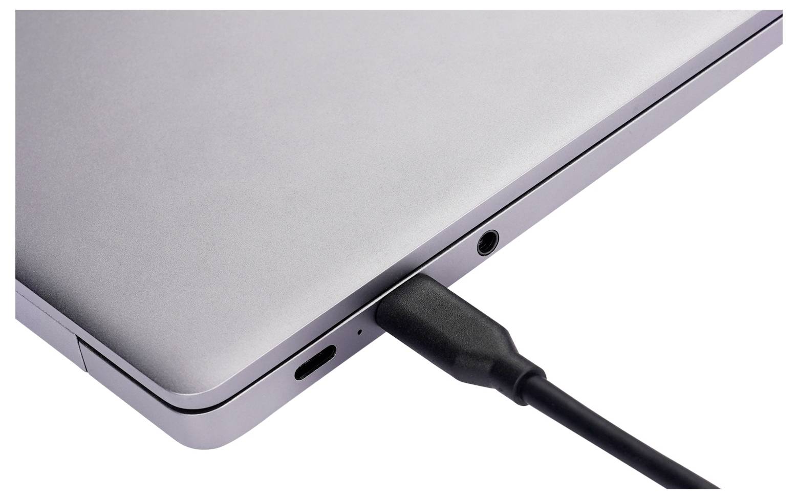 Detailní záběr na hranu notebooku se konektorem USB-C pro nabíjení zasunutým do bočního portu.