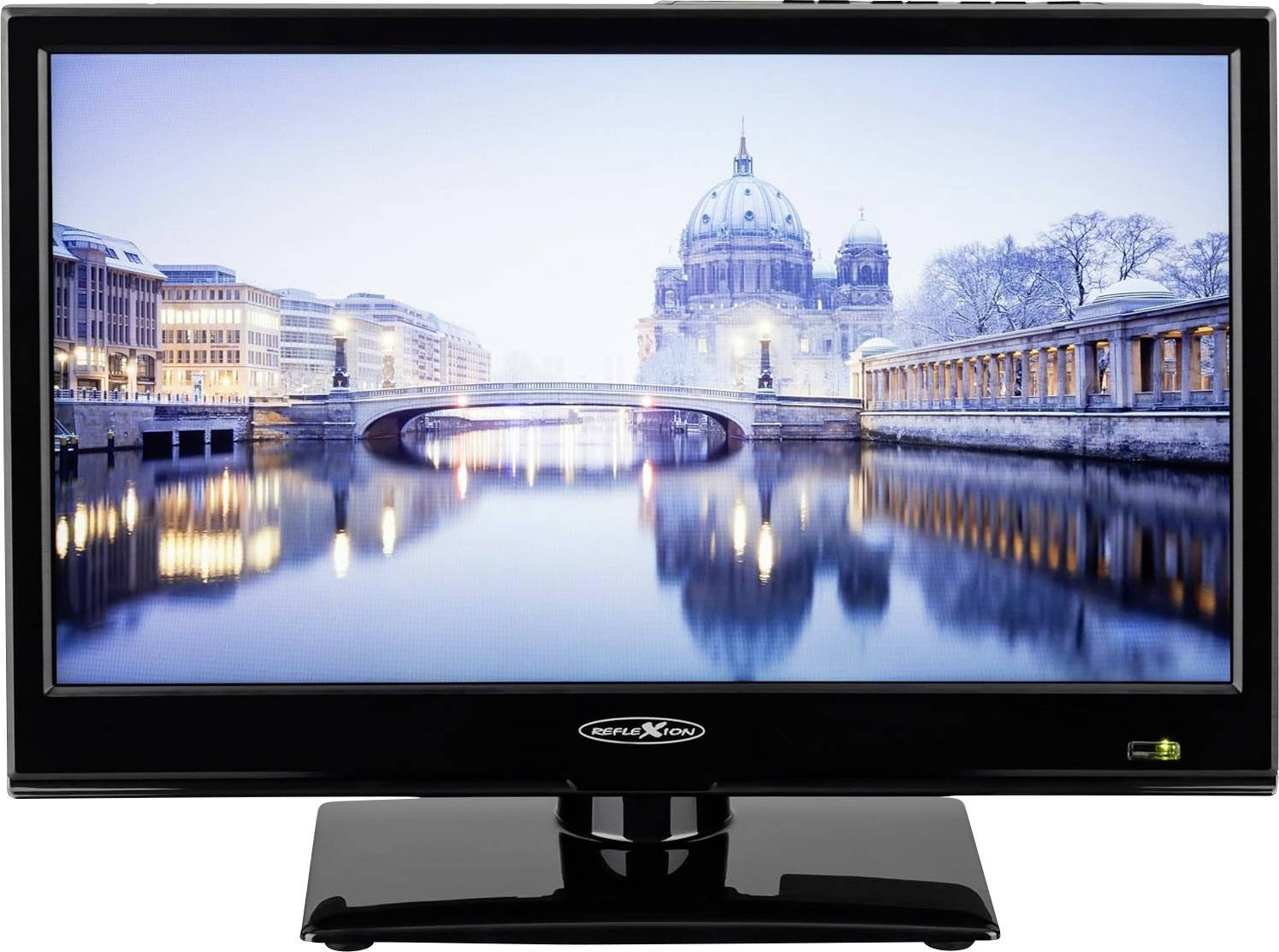 Plochá televize zobrazující městskou krajinu s kupolí katedrály a mostem odrážejícím se v řece při soumraku.