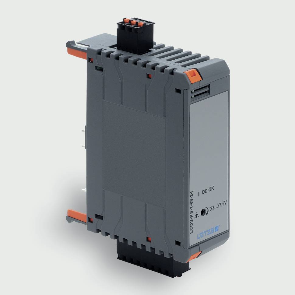 Šedý průmyslový elektronický modul s oranžovými jazykama a popiskem na boku, zobrazený v izolaci na světlém pozadí.