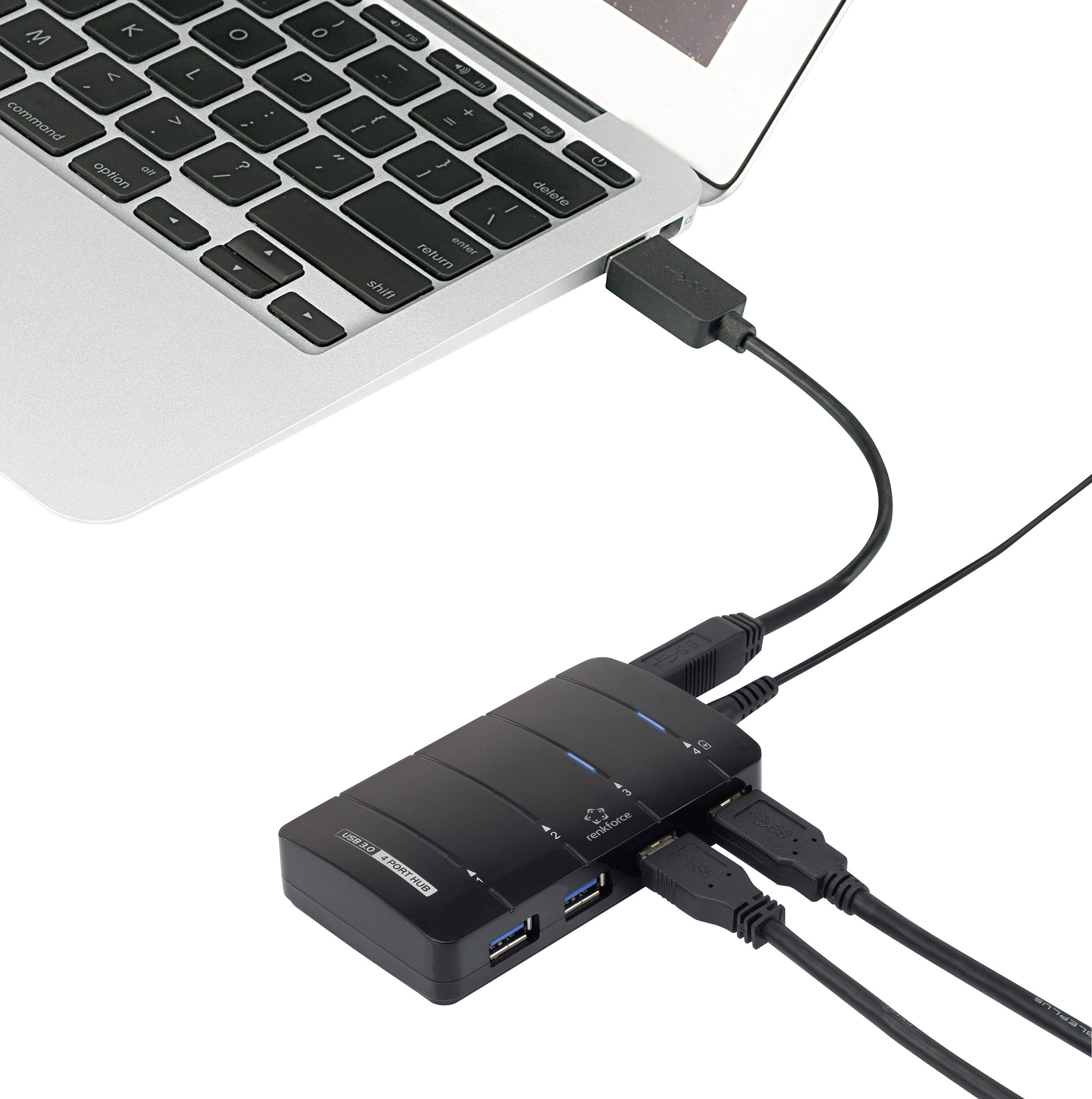 USB hub je připojen k několika kabelům a zapojen do laptopového počítače. Laptop je částečně viditelný.