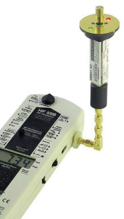 Měřicí přístroj s připojeným senzorem ukazuje intenzitu elektromagnetického pole. Na displeji je zobrazeno '7.34'.