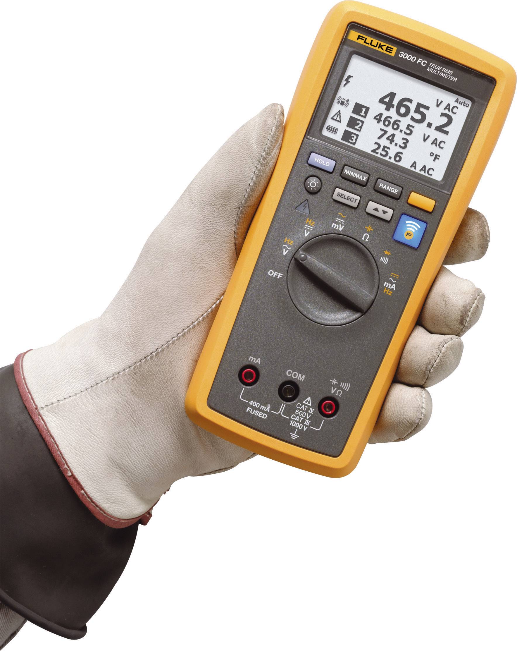 Jedna ruka drží digitální multimetr zobrazující napětí a teplotu. Hodnoty na displeji: 465,2 V AC, 25,6 °C.