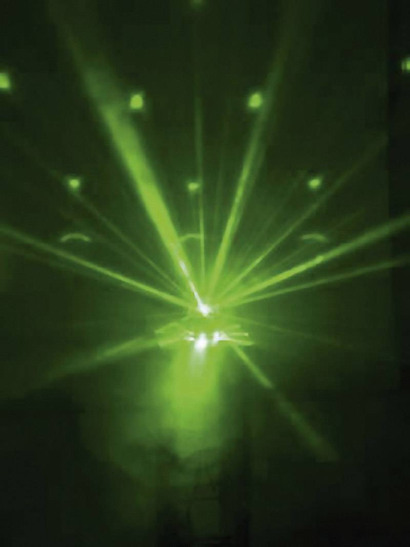 Zelené laserové paprsky září různými směry a vytvářejí hvězdicovitý vzor ve tmě. Atmosférické osvětlovací efekty.