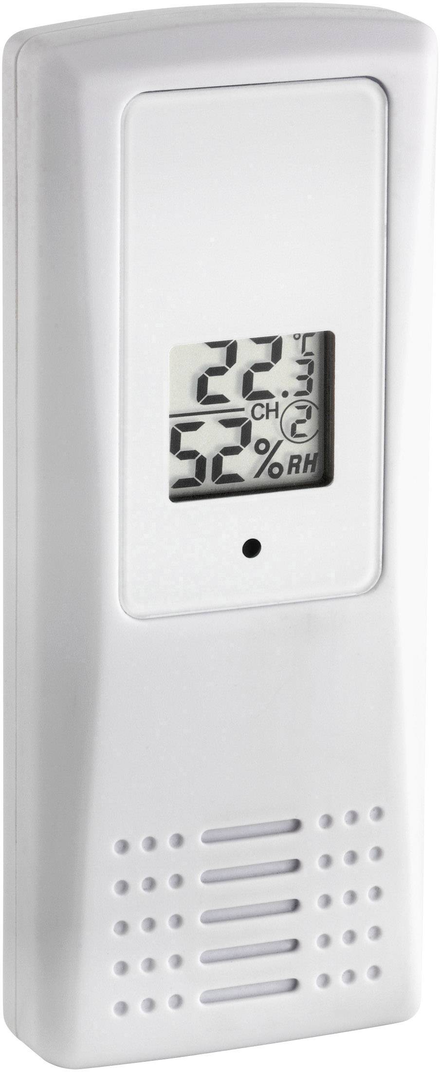 Bílý digitální teploměr s vlhkoměrem ukazuje '22°C' a '52% RV'.