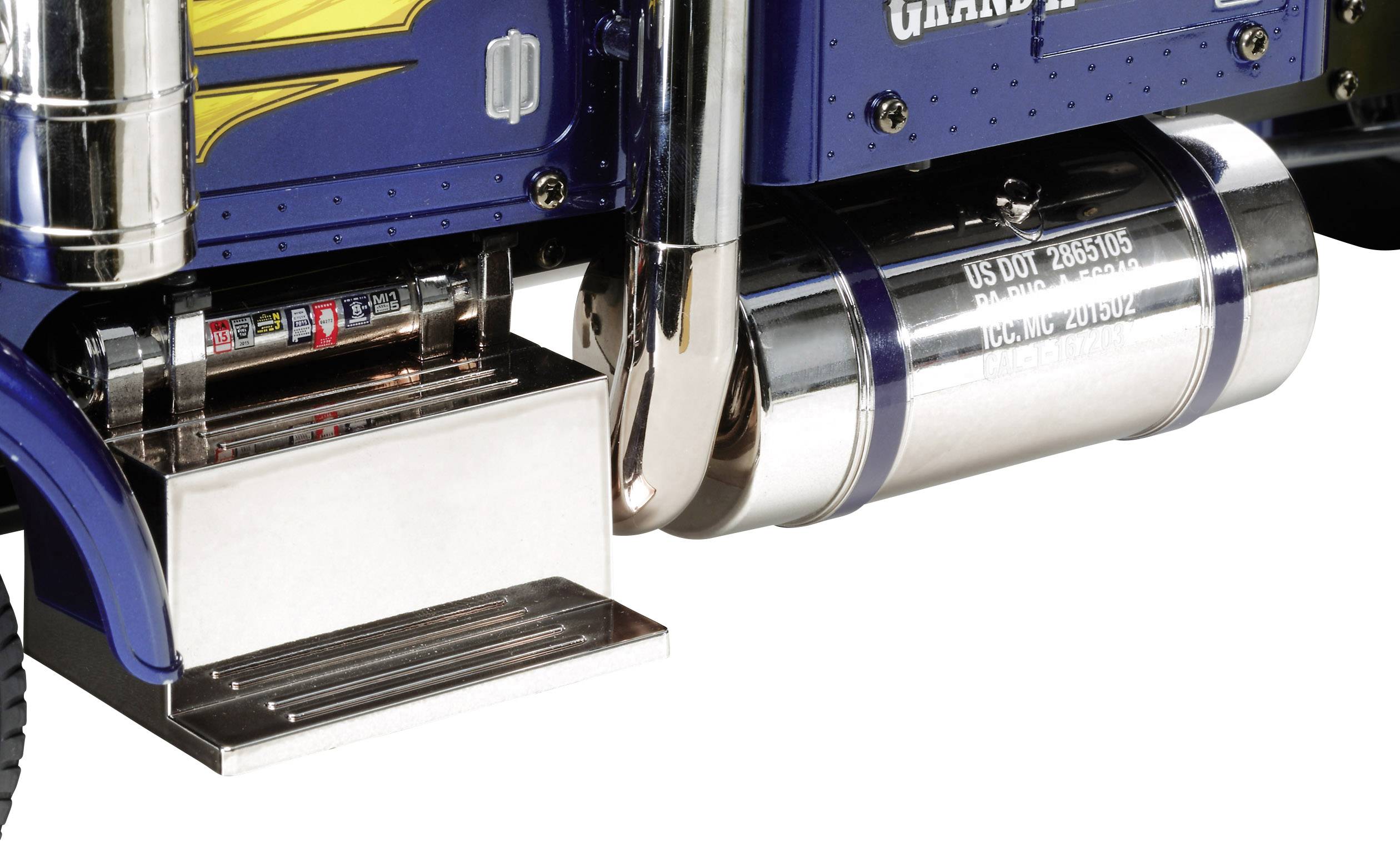 Detailní pohled na vyrovnávací nádrž nákladního automobilu z nerezové oceli s vytištěnými čísly a výfukovým potrubím, obklopený modrou výplní.