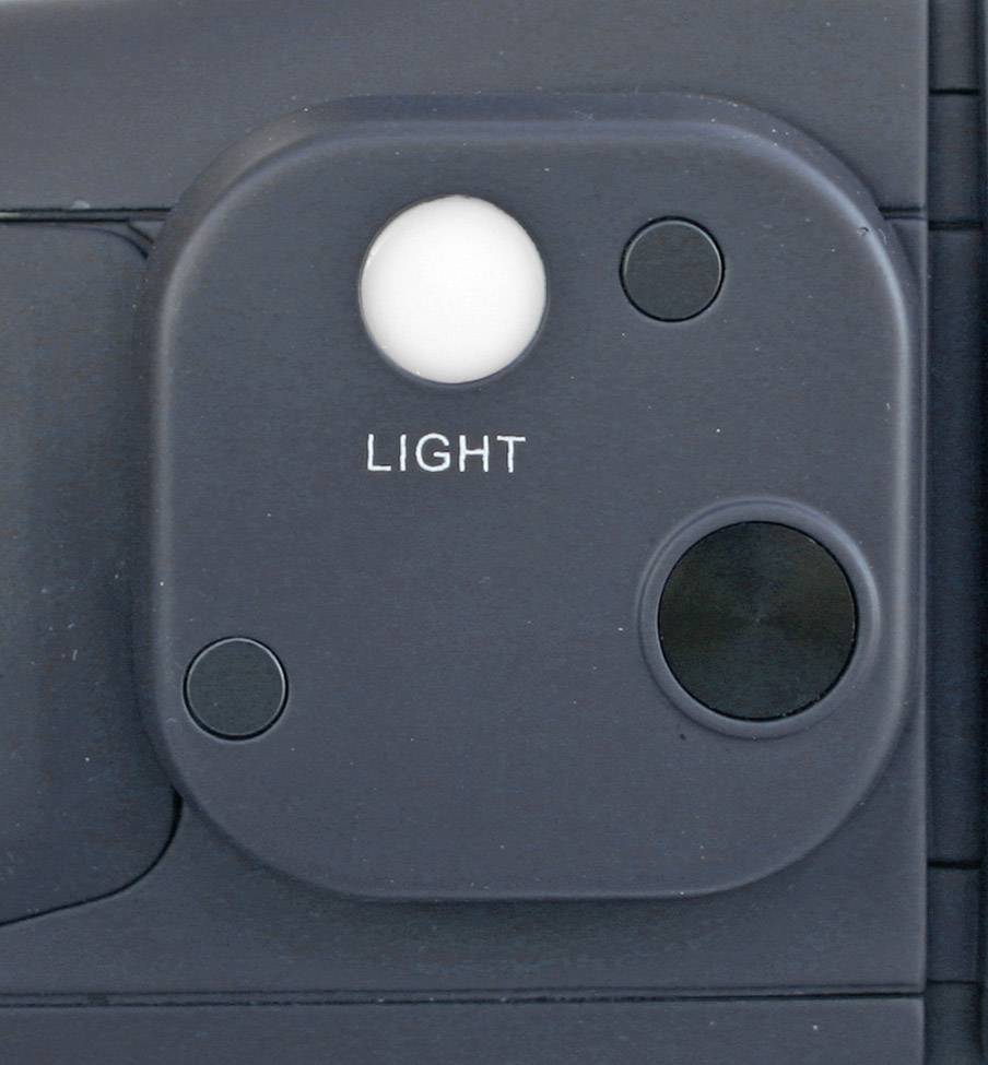 Detailní záběr světla polaroidního fotoaparátu, čtvercový modul s nápisem 'LIGHT' pod bílým senzorovým polem, obklopený třemi černými senzory.