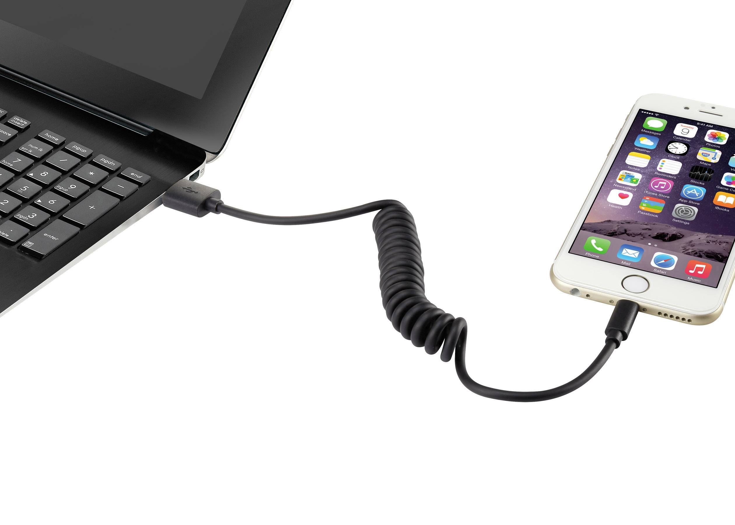 Notebook připojený ke smartphonu spirálovým kabelem zobrazuje nabíjení nebo přenos dat mezi zařízeními.