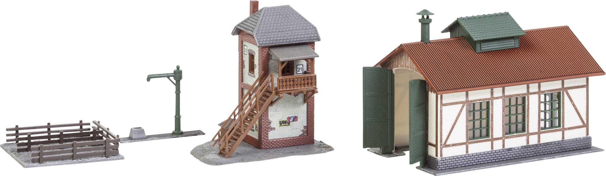Miniaturní model nádraží s chlévem, vodní nádrží a hrázděnou budovou. Ideální pro železniční krajinu.