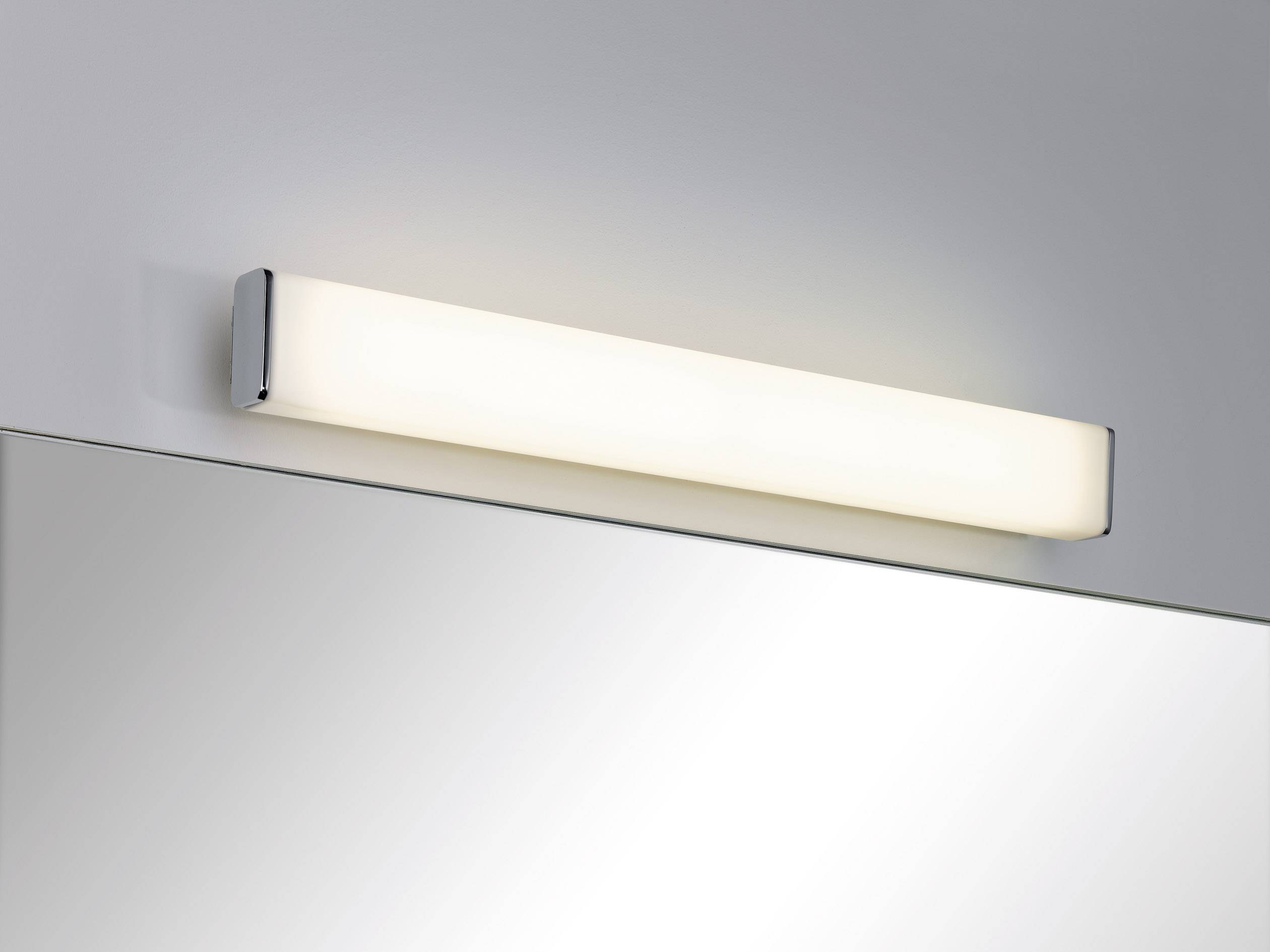 Bílé LED nástěnné svítidlo nad zrcadlem, které poskytuje měkké světlo pro rovnoměrné osvětlení. Ideální do koupelny.