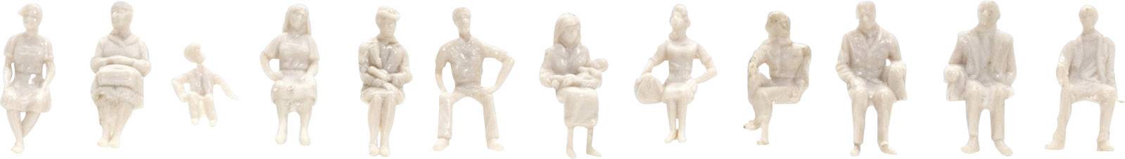 Dvanáct bílých figur sedí v řadě, každá v různých pózách a velikostech.