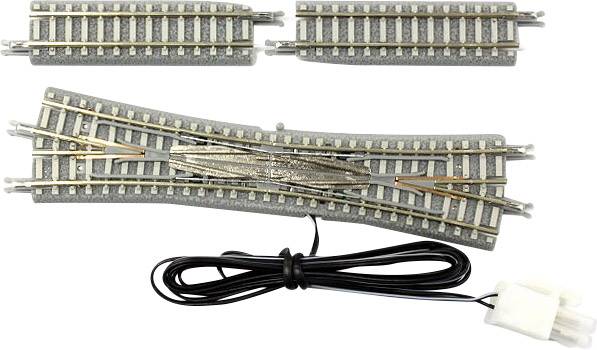 Sada modelářských kolejí s výhybkou a dvěma přímými úseky. Černý kabel s bílou zástrčkou je rovněž viditelný.
