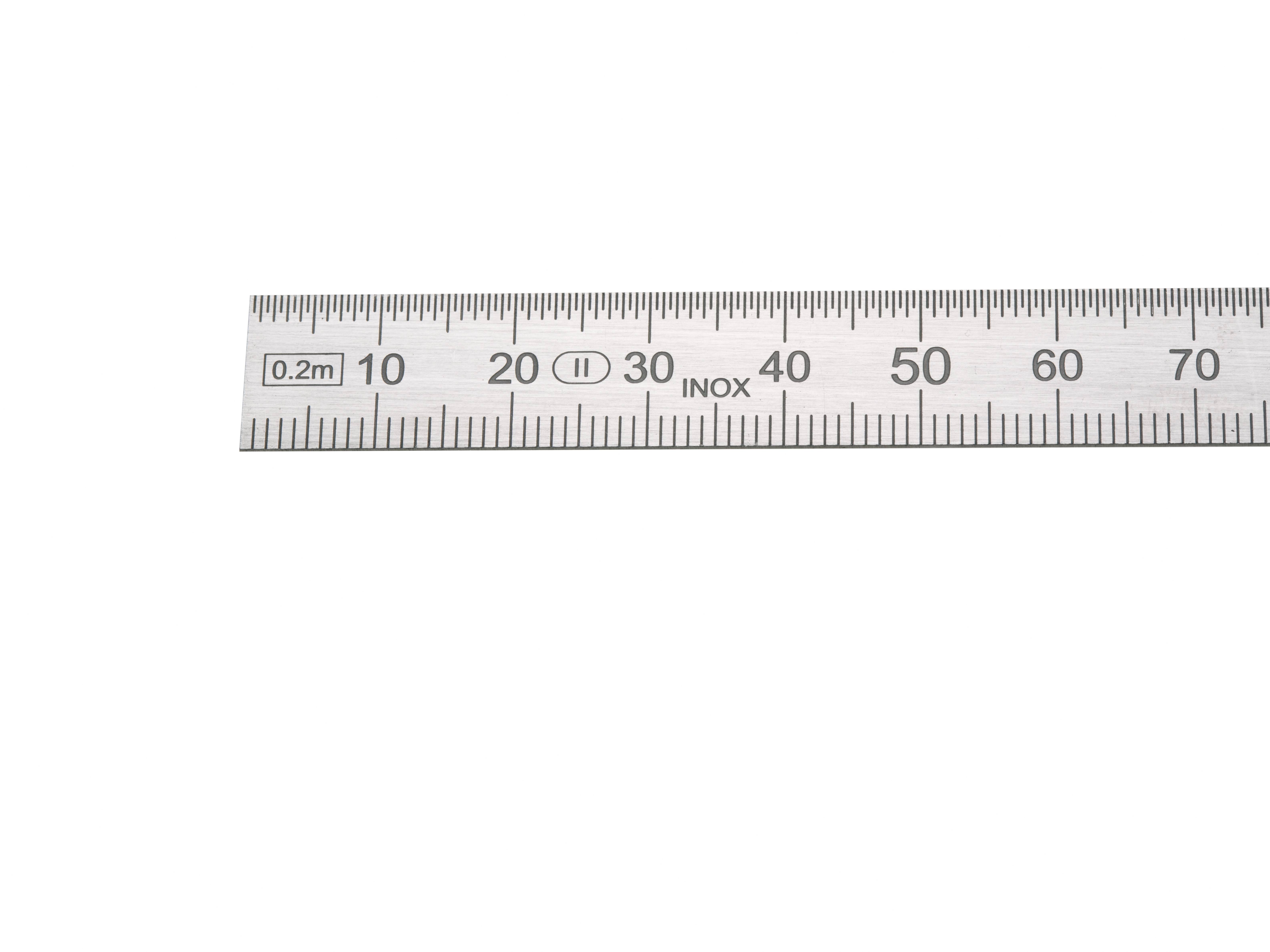 Kovové měřítko s centimetrovou a milimetrovou stupnicí, ukazuje až 60 cm.