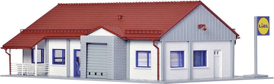 Malá modelová budova s červenou střechou, modrými okny a štítkem s žlutým pozadím a logem na pravém okraji.