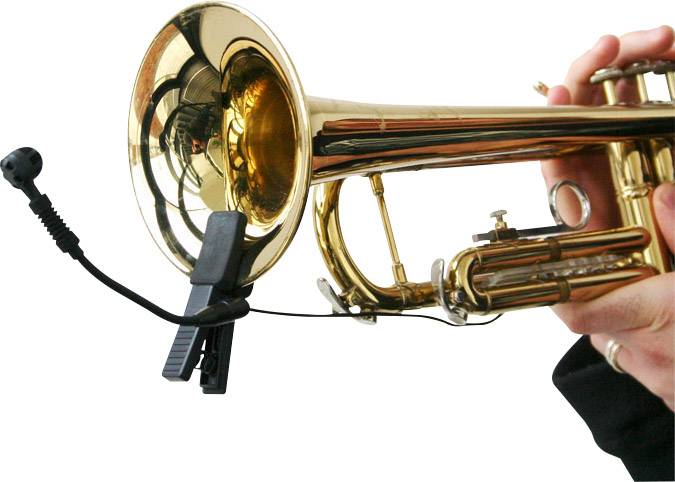 Osoba hraje na trumpetu, která je připevněna mikrofonem snímajícím zvuk.