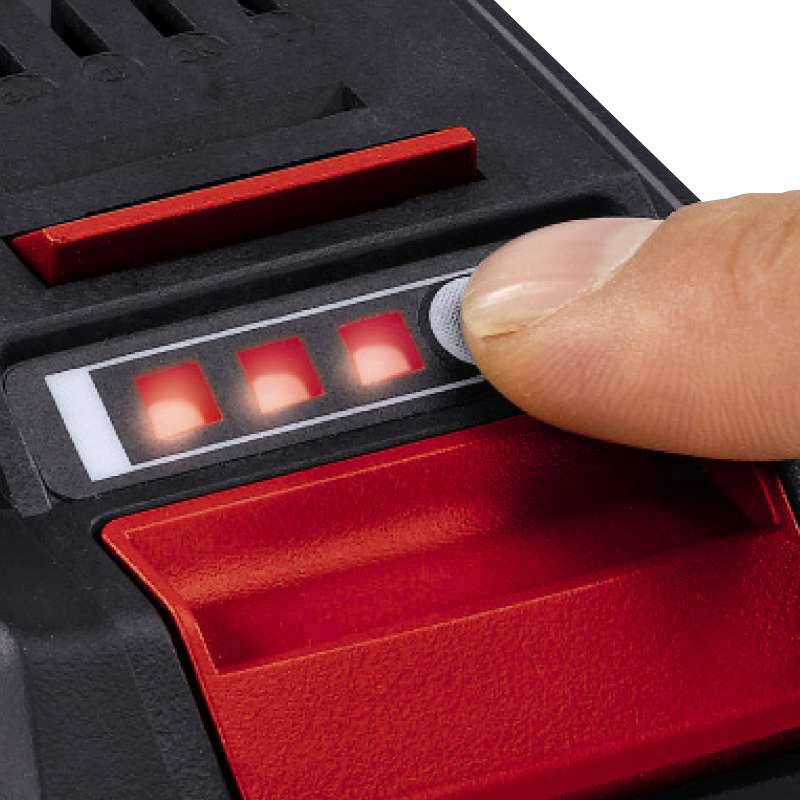 Prst tiskne na osvětlené tlačítko elektronického zařízení, obklopené červenými světly a displejem.