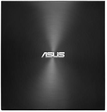 Černý, lesklý kryt notebooku s bílým logem Asus uprostřed. Design ukazuje soustředné, kruhové vzory.