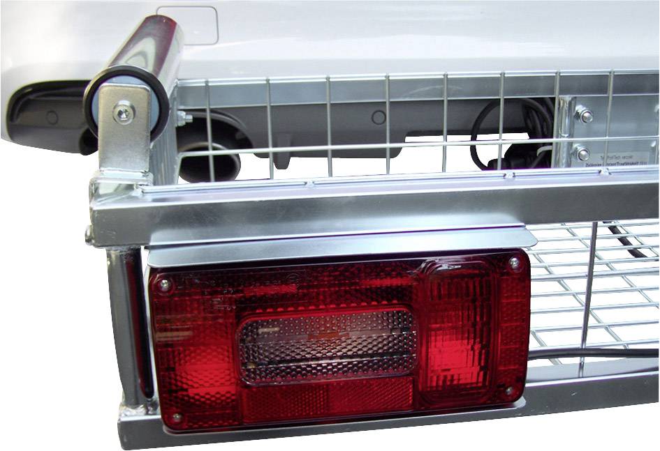 Detailní záběr tažného nosiče připevněného na zadní části automobilu, s červeným zadním světlem a drátěným košem, zobrazující mechanismus upevnění a pohled zezadu.